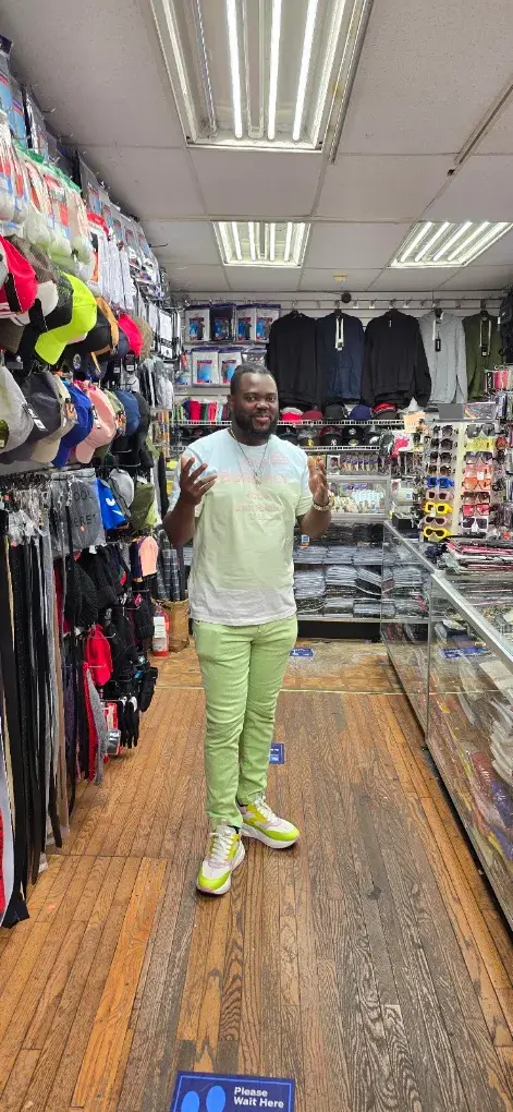 Customer in green outfit by the cap wall