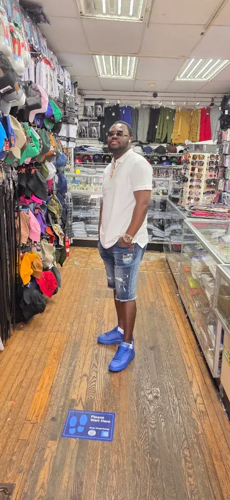 Customer in white polo and blue sneakers in the store aisle
