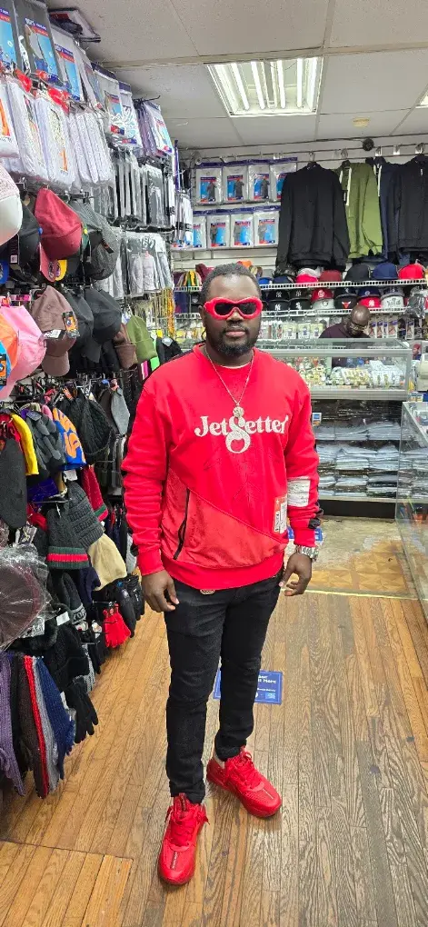 Customer in a red JetSetter sweatshirt by the caps